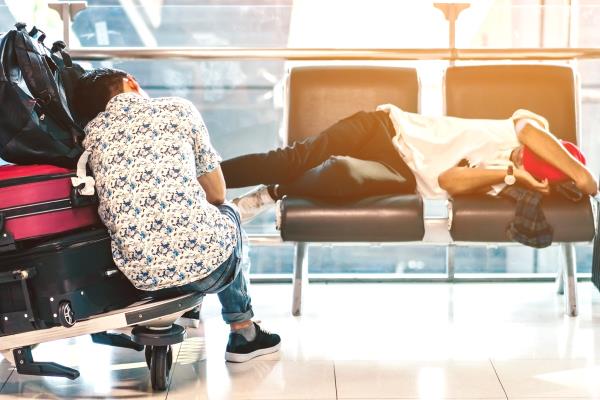 two travelers sleep in an airport